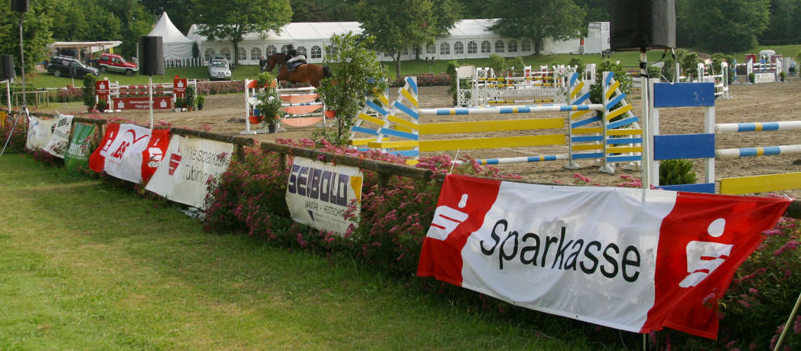 Springparcours mit Hindernissen und Sponsorentafeln